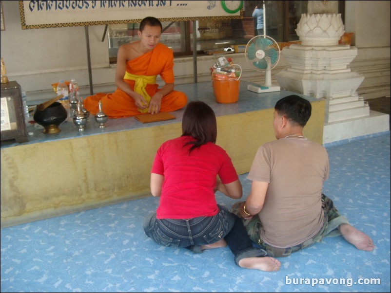 A couple speaking with a Buddhist monk, Wat Phananchoeng.