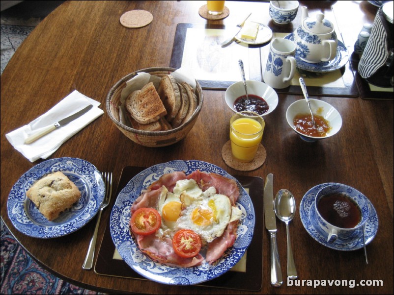 Mrs. Hippisley's breakfast: scones, toast, bacon, eggs, tomato, orange juice, tea, coffee.